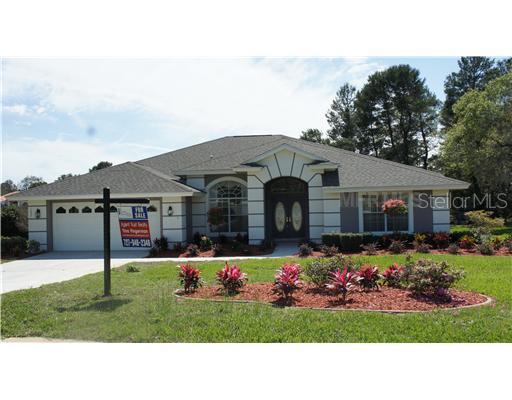 1027 Rudolph Court Spring Hill, FL 34609 - Photo 1 of 1 a front view of house with yard and trees