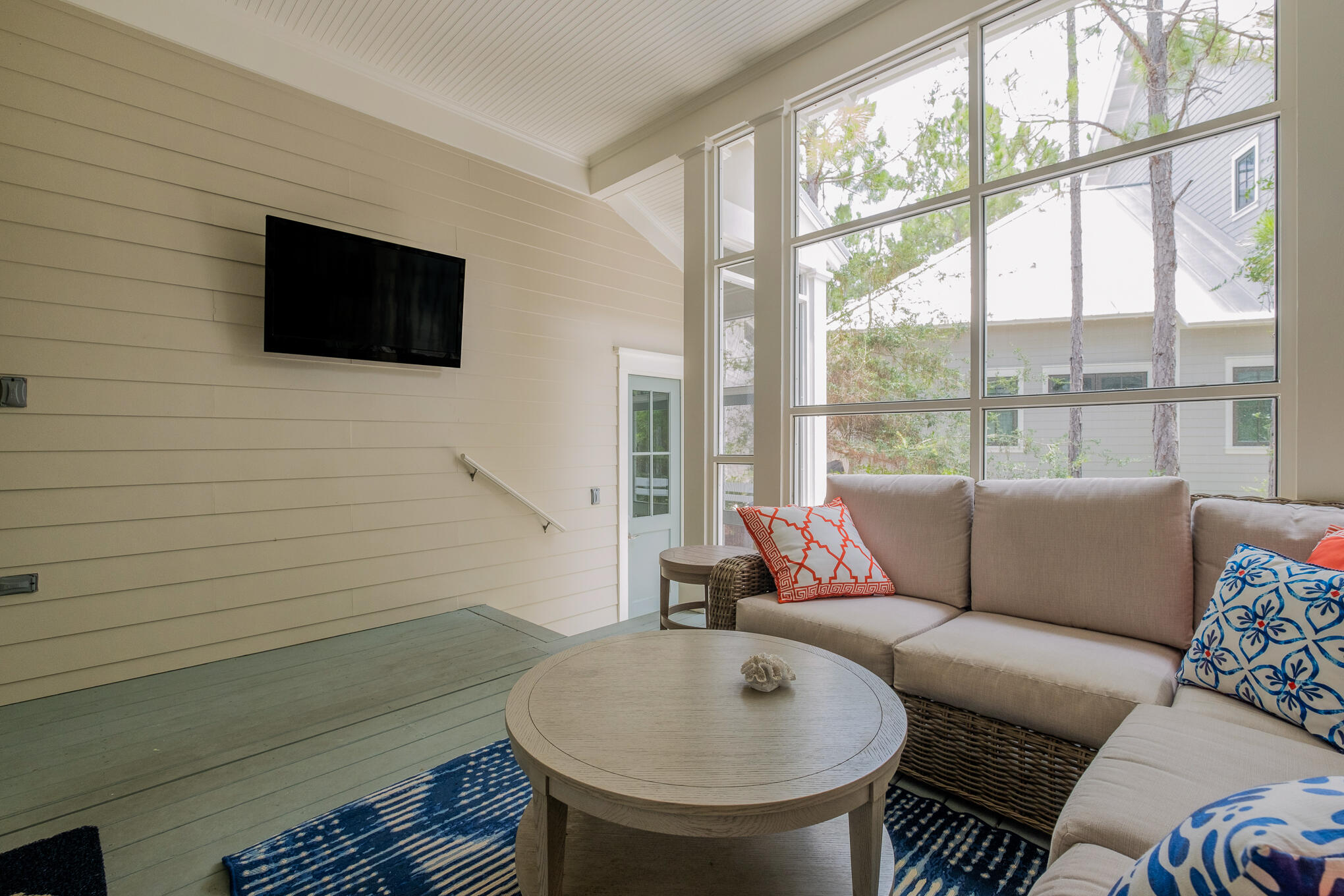 296 Pine Needle Way Santa Rosa Beach, FL 32459 - Photo 26 of 61 a living room with furniture a flat screen tv and a floor to ceiling window