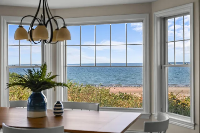 a vase of flowers sitting on a table with window