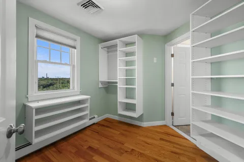 a view of bedroom with wooden floor and windows