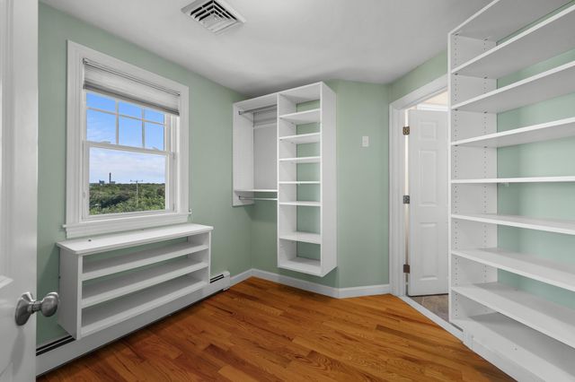 a view of bedroom with wooden floor and windows