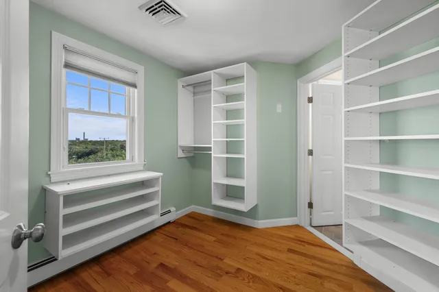 a view of bedroom with wooden floor and windows