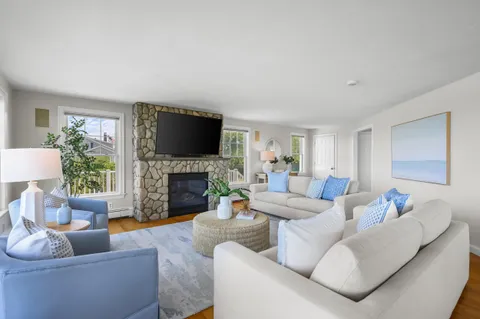 a living room with furniture a fireplace and a flat screen tv