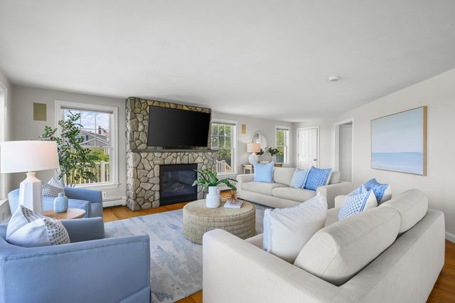 a living room with furniture a fireplace and a flat screen tv