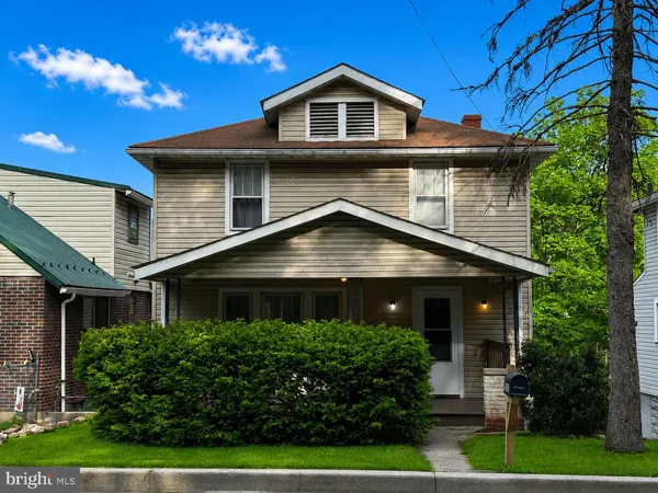a front view of a house with yard and green space