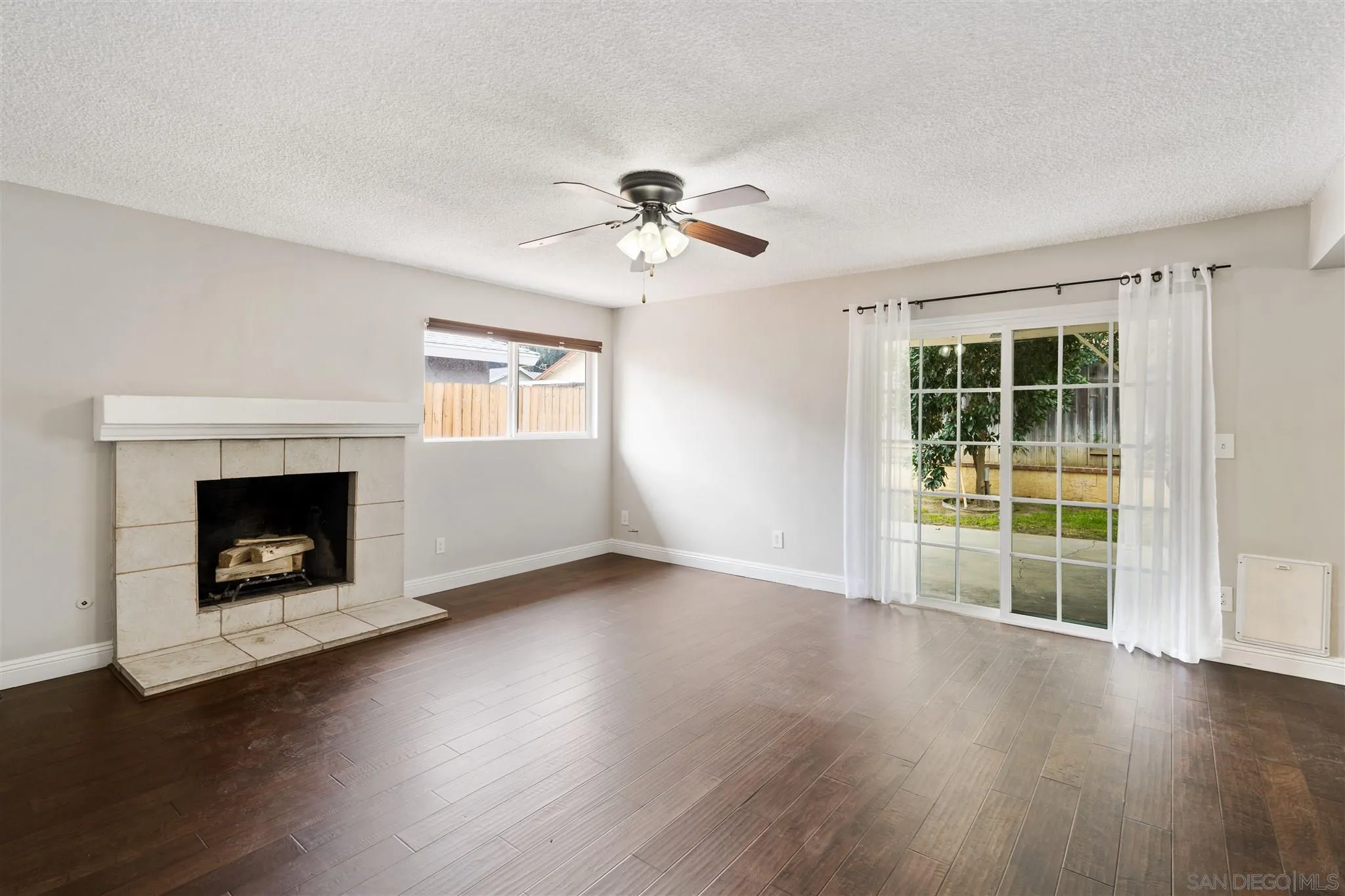 7752 Bayberry Avenue Riverside, CA 92504 - Photo 7 of 27 a view of a livingroom with a fireplace wooden floor and windows