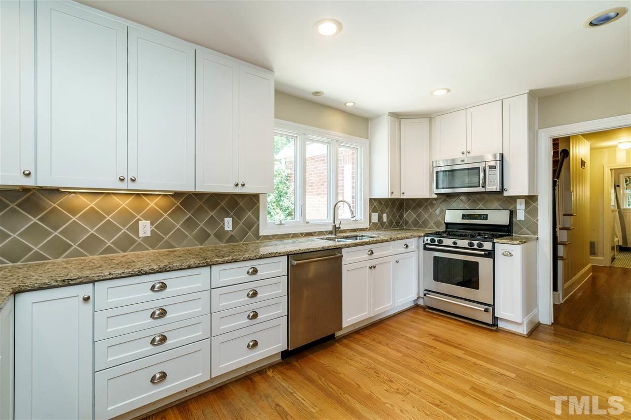 512 Burton Street Raleigh, NC 27608 - Photo 11 of 24 a kitchen with granite countertop cabinets and steel stainless steel appliances