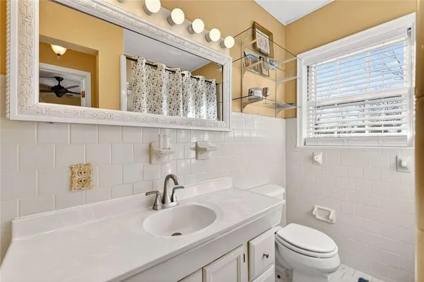 a bathroom with a sink a toilet and a large mirror