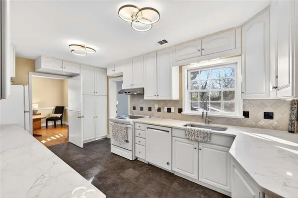 a kitchen with stainless steel appliances white cabinets and a refrigerator