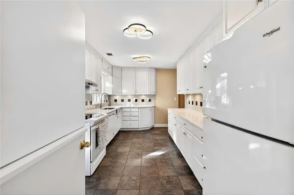 a view of a livingroom with furniture a chandelier and wooden floor