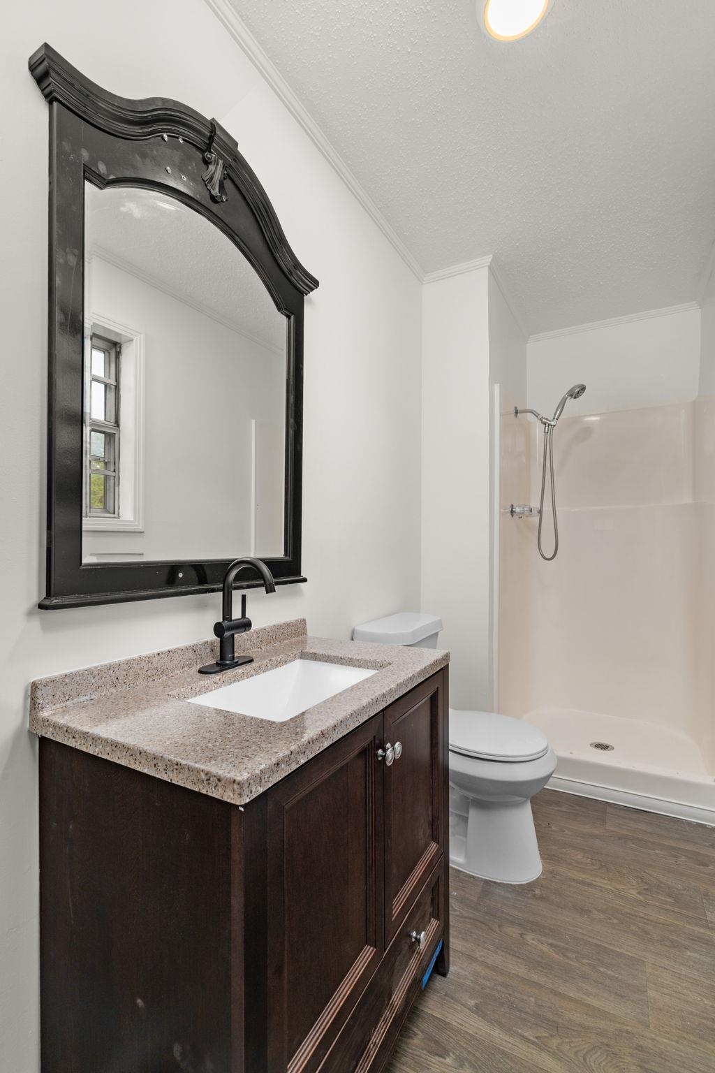 217 Red Bay Road Golden, MS 38847 - Photo 14 of 33 Bathroom featuring a dark wood-finish vanity with a speckled countertop, an undermount sink, and a matte black faucet