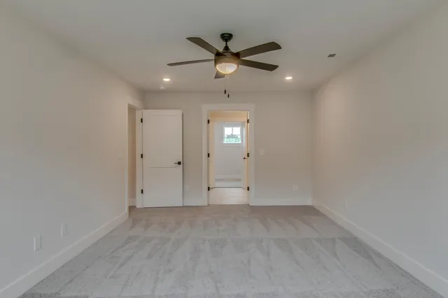 an empty room with ceiling fan and window