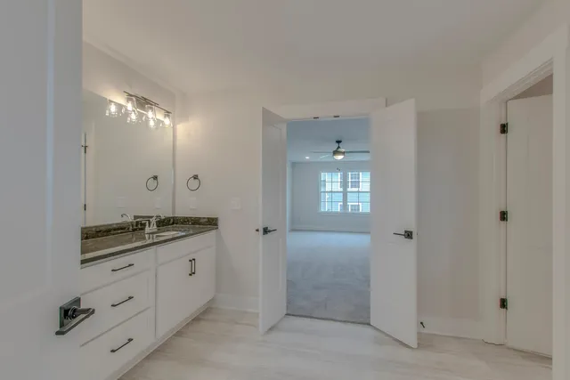 a spacious bathroom with a granite countertop sink a mirror and a shower