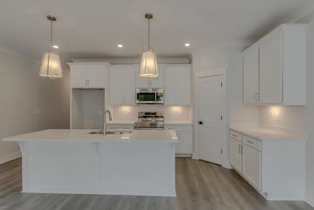 a kitchen with kitchen island white cabinets and stainless steel appliances
