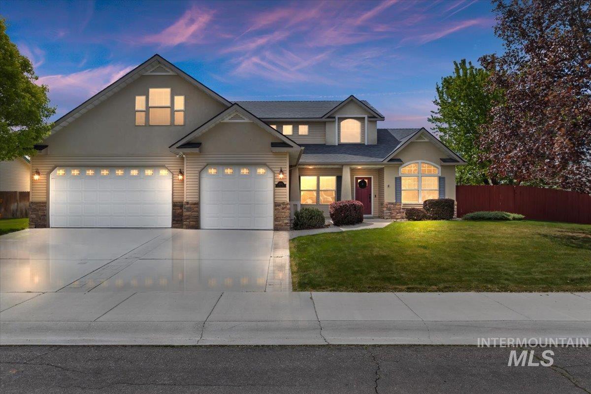 Two-story residence featuring a two-car garage, a single-car garage, and a concrete driveway