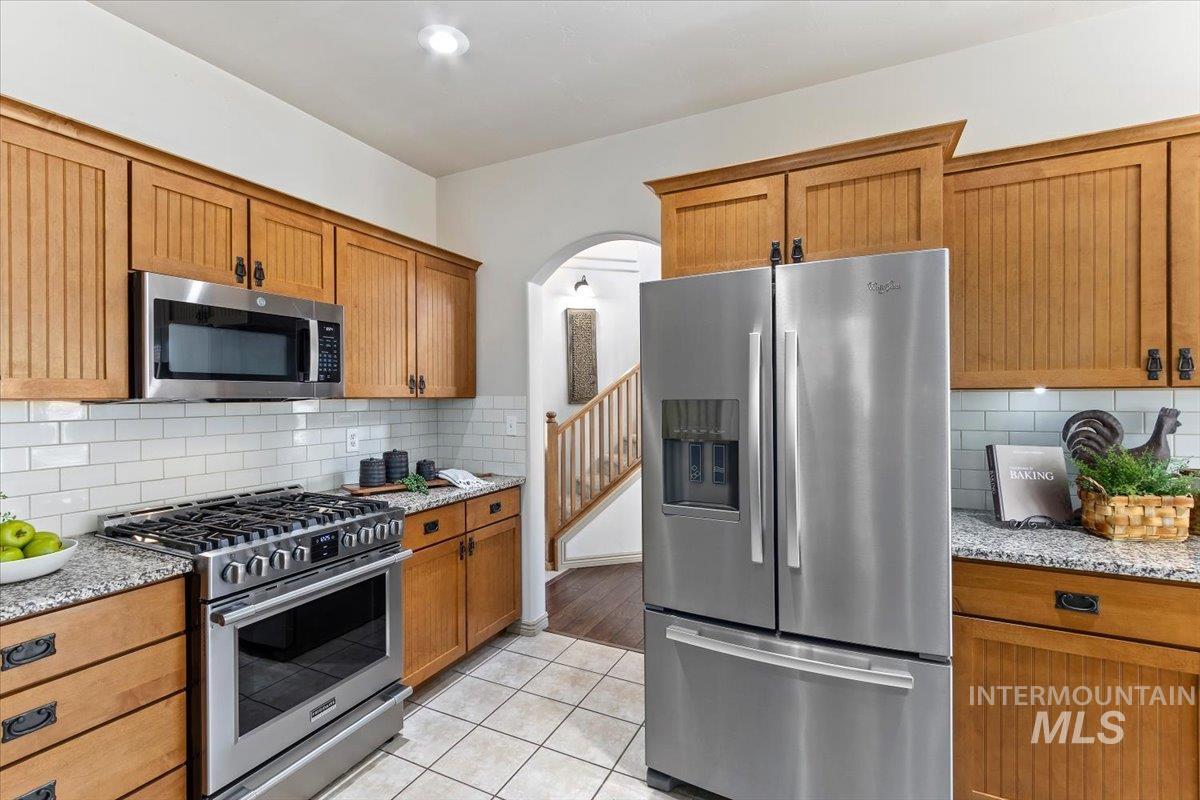 2274 Eastwood Road Twin Falls, ID 83301 - Photo 13 of 38 Kitchen featuring stainless steel appliances, wood cabinetry, granite countertops, and subway tile backsplash