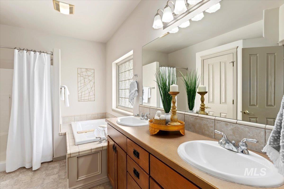 2274 Eastwood Road Twin Falls, ID 83301 - Photo 17 of 38 Full-width mirror spanning dual inset sinks with chrome hardware and a wood-finish vanity