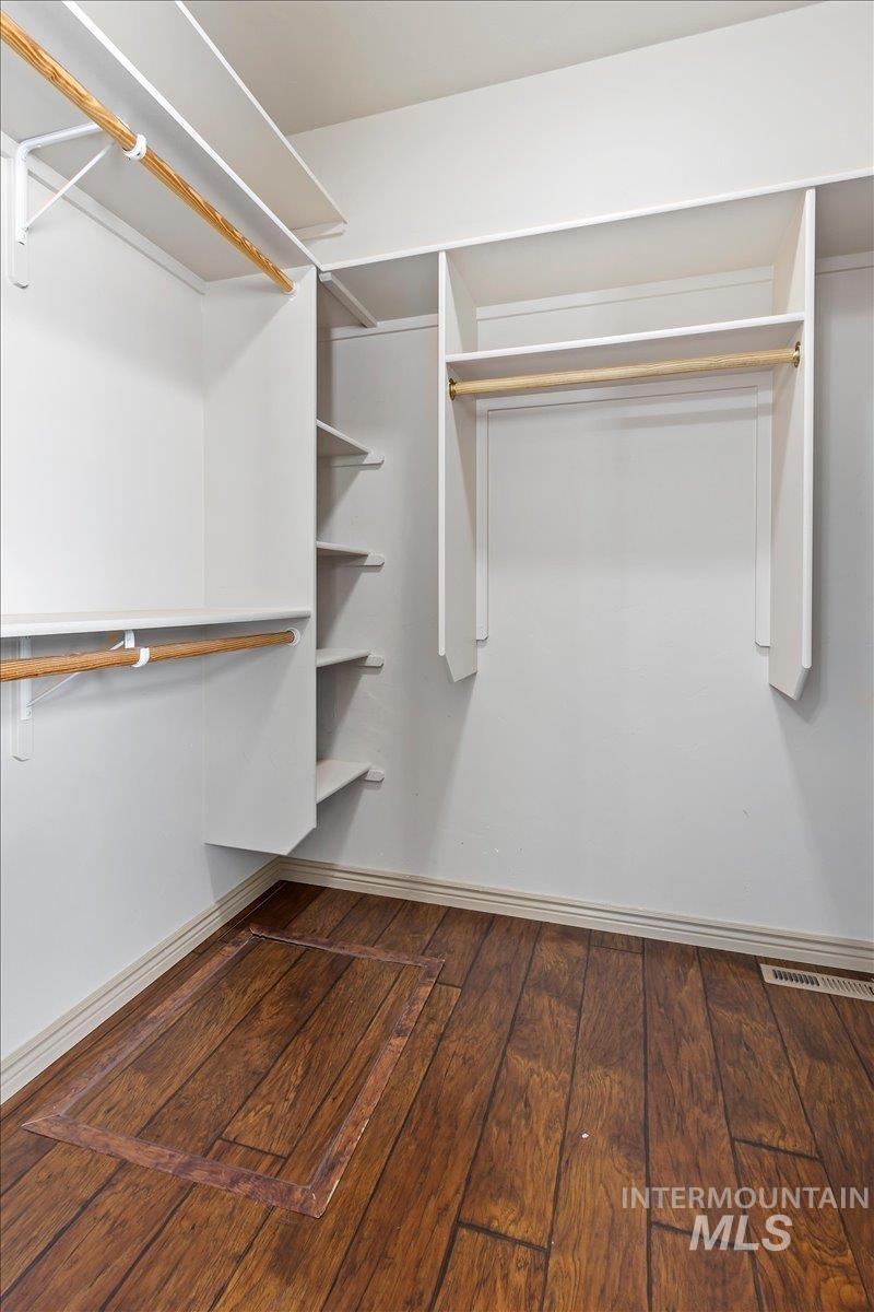 2274 Eastwood Road Twin Falls, ID 83301 - Photo 20 of 38 Walk-in closet featuring wood-finish flooring, white built-in shelving, multiple hanging rods, and white baseboards