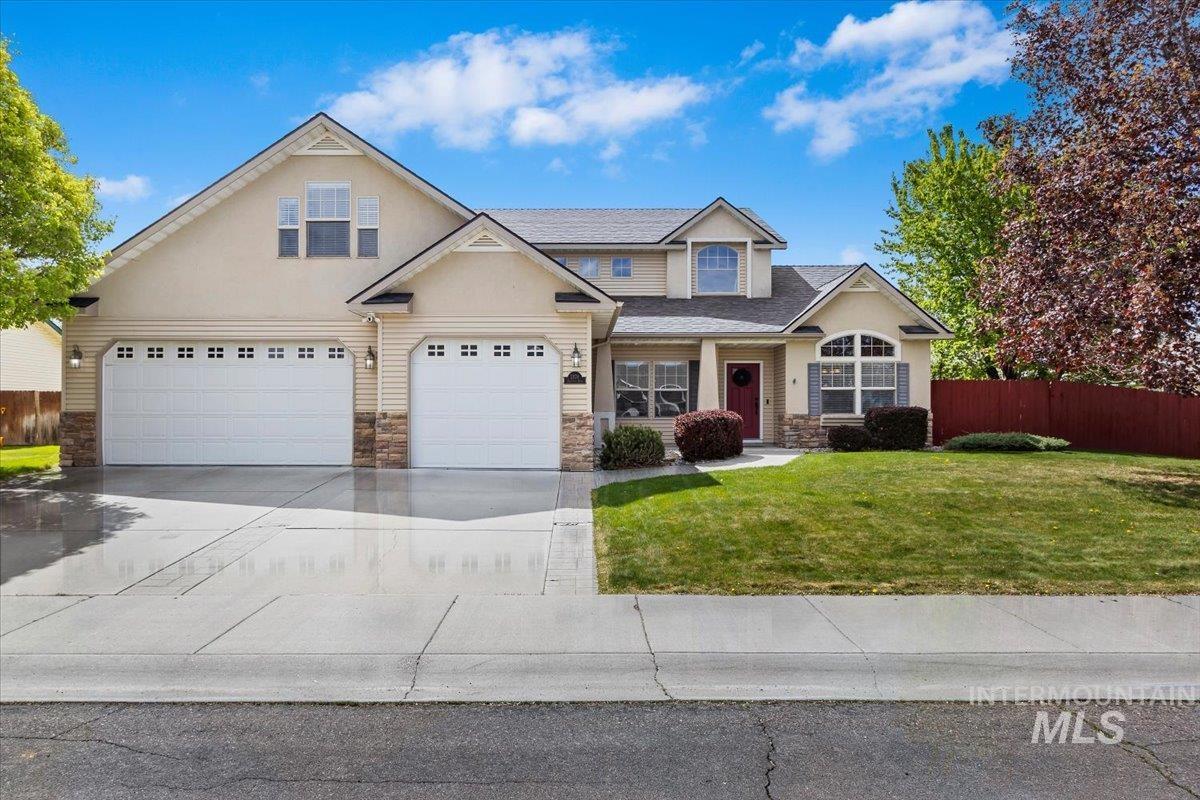 2274 Eastwood Road Twin Falls, ID 83301 - Photo 2 of 38 Two-story residence featuring a three-car garage, stone accents, and a covered entry with a red door