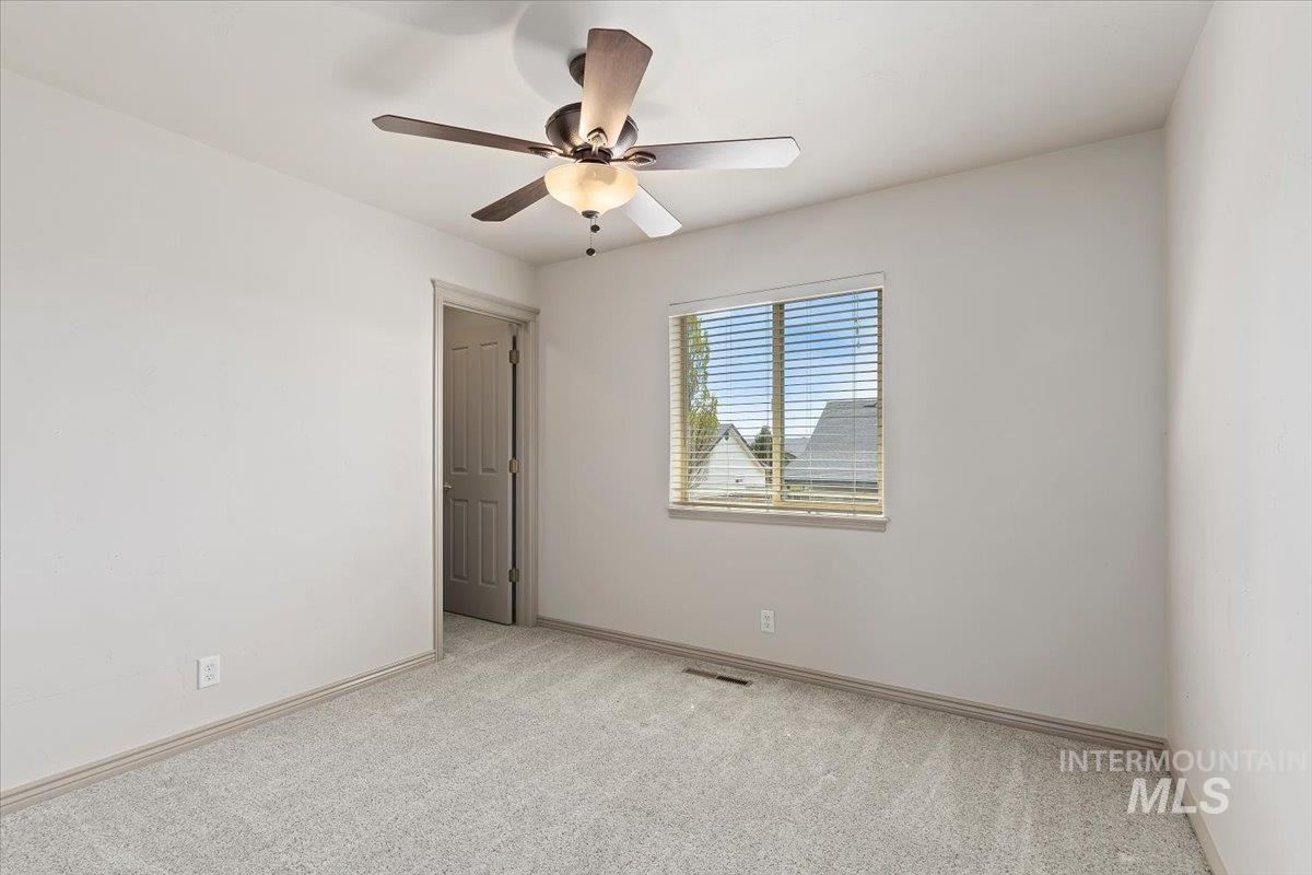 2274 Eastwood Road Twin Falls, ID 83301 - Photo 21 of 38 Room featuring light gray carpeting, a window with horizontal blinds, and a ceiling fan with integrated lighting