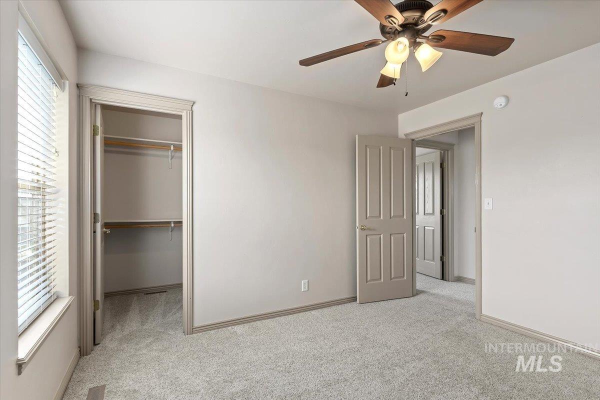 2274 Eastwood Road Twin Falls, ID 83301 - Photo 23 of 38 Carpeted room with a ceiling fan light fixture, window with horizontal blinds, and a walk-in closet with shelving and hanging rods