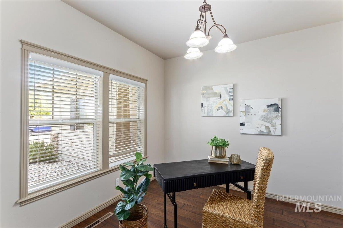 2274 Eastwood Road Twin Falls, ID 83301 - Photo 29 of 38 Bright room featuring a multi-pane window with louvered blinds, warm wood-finish flooring, and a bronze-finish ceiling light fixture