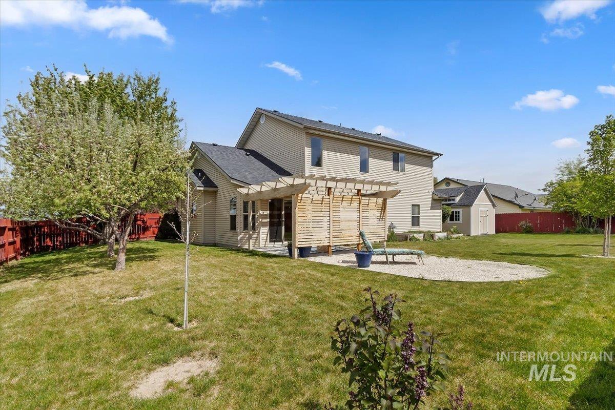 2274 Eastwood Road Twin Falls, ID 83301 - Photo 32 of 38 Expansive backyard featuring a large gravel patio, a wood pergola structure, and a mature tree