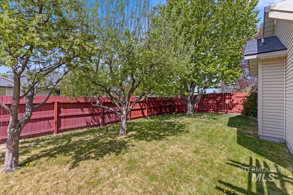 2274 Eastwood Road Twin Falls, ID 83301 - Photo 33 of 38 Expansive backyard featuring a manicured lawn, established trees, and a privacy fence