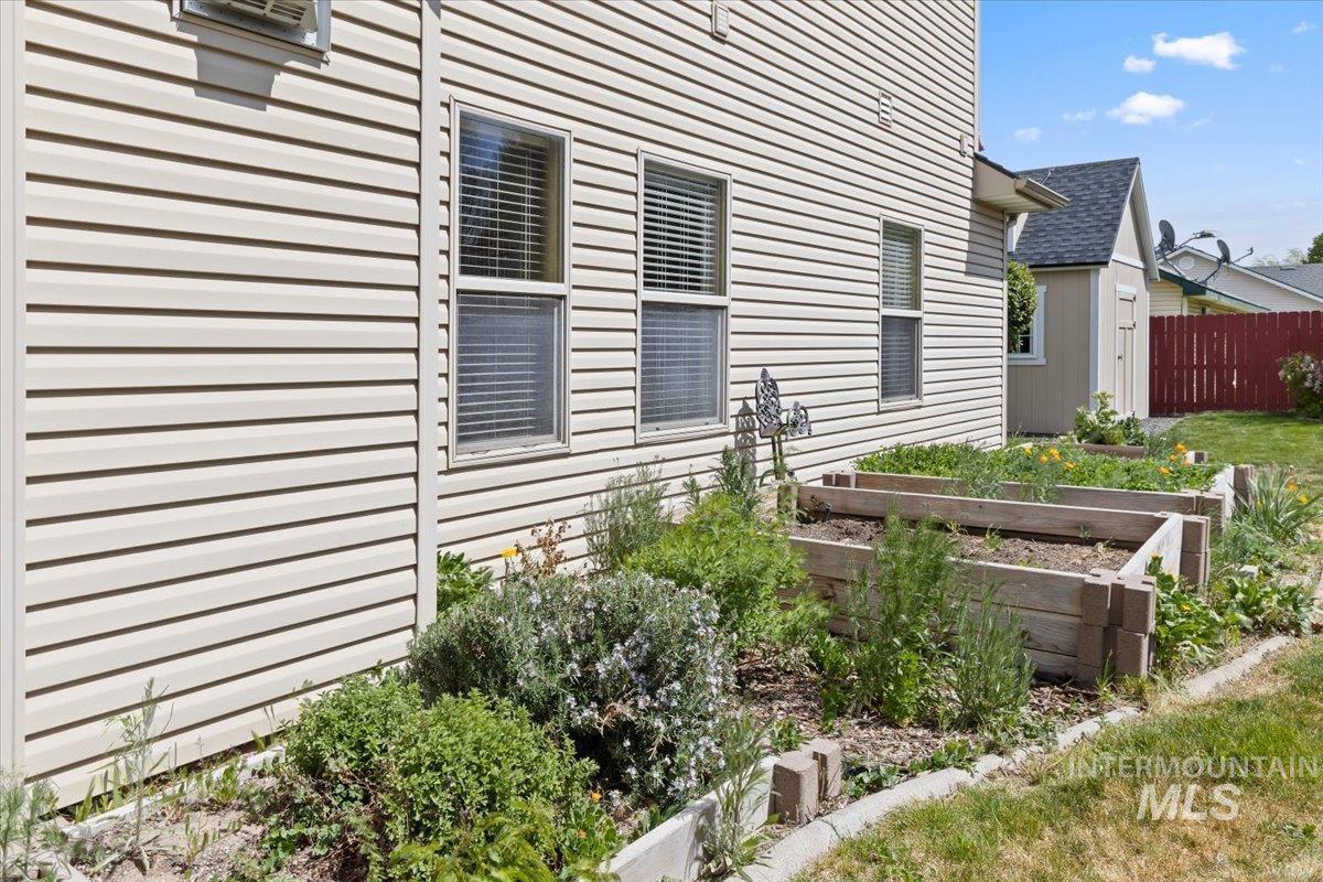 2274 Eastwood Road Twin Falls, ID 83301 - Photo 38 of 38 Exterior featuring horizontal vinyl siding, multiple windows with blinds, wood-raised garden beds, and a concrete border