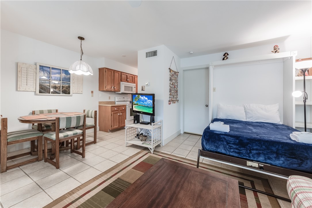 622 Beach Access Road, Unit 225 Port Aransas, TX 78373 - Photo 12 of 21 a living room with furniture a dining table and chairs with wooden floor