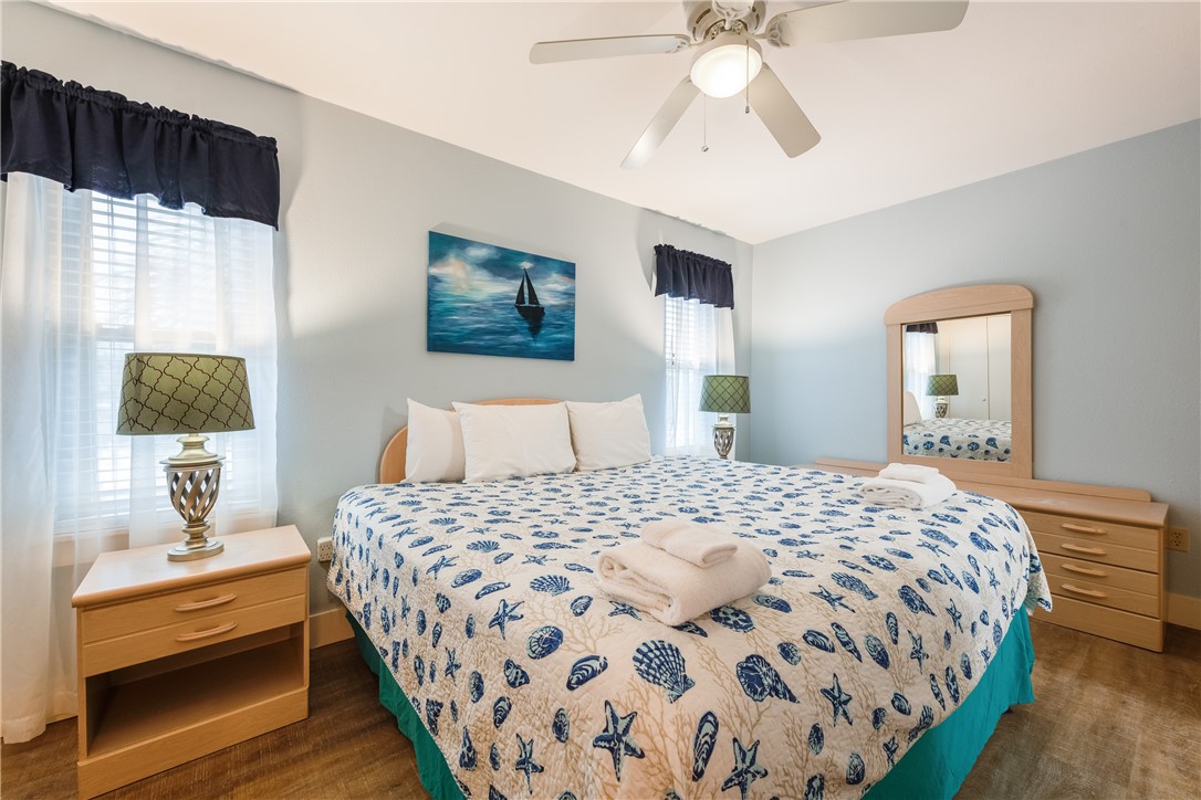 622 Beach Access Road, Unit 225 Port Aransas, TX 78373 - Photo 18 of 21 a bedroom with a bed and a chandelier