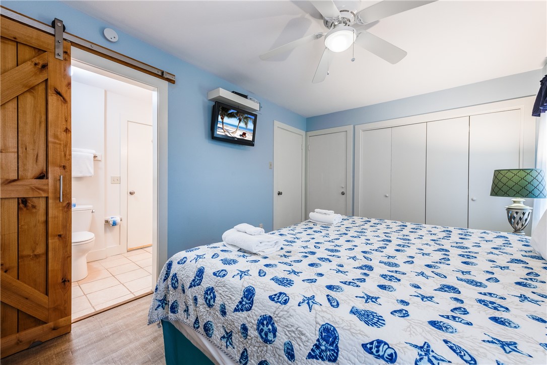 622 Beach Access Road, Unit 225 Port Aransas, TX 78373 - Photo 20 of 21 a bedroom with a bed and a chandelier