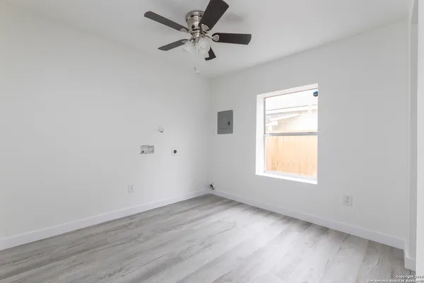 an empty room with a window and a fan