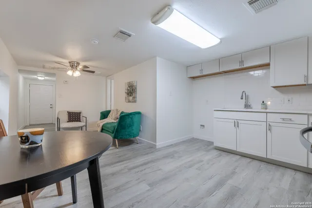 a kitchen with a table chairs refrigerator and microwave
