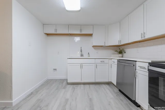 a kitchen with white cabinets appliances and sink