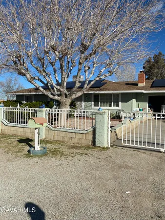 a view of a white house with a yard porch and sitting area