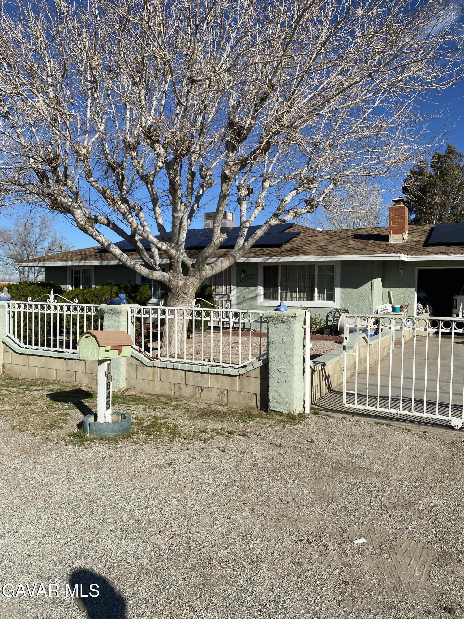 10845 East Ave R-2 Littlerock, CA 93543 - Photo 1 of 4 a view of a white house with a yard porch and sitting area