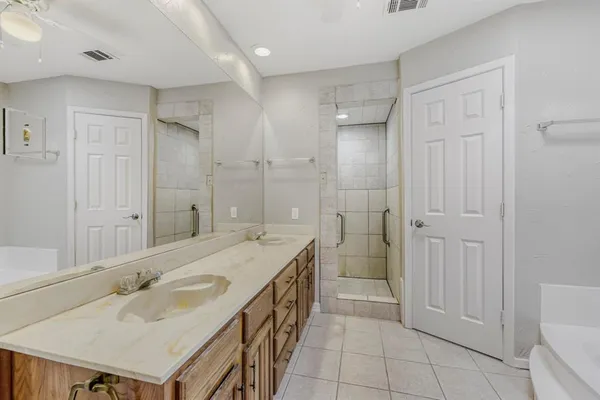 a spacious bathroom with a tub shower vanity and a sink