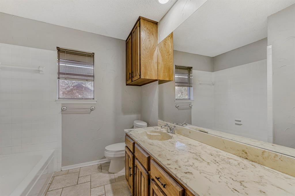 517 Kings Gate Road Willow Park, TX 76087 - Photo 17 of 28 a bathroom with a granite countertop sink toilet and mirror