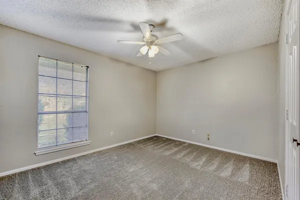a view of an empty room with a ceiling fan