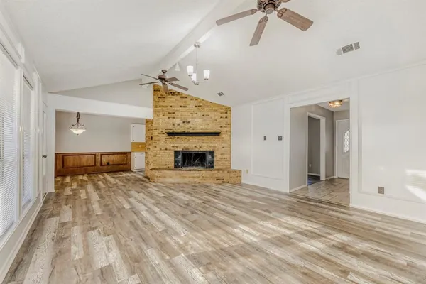 a view of empty room with fireplace and fan