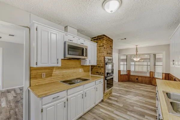a kitchen with granite countertop a sink stove and cabinets