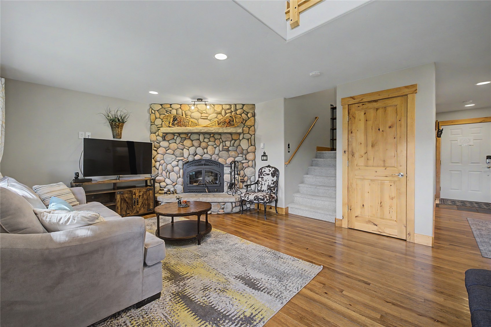 6726 Ryan Gulch Road, Unit 6726 Wildernest, CO 80498 - Photo 25 of 39 a living room with furniture a flat screen tv and a fireplace