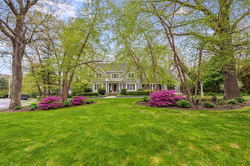 a view of a house with a big yard and large trees