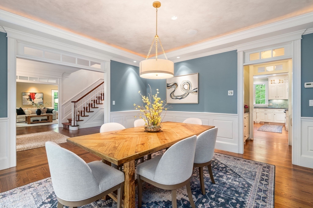 200 Edgewater Drive Needham, MA 02492 - Photo 7 of 41 a dining room with wooden floor a chandelier a wooden table and chairs
