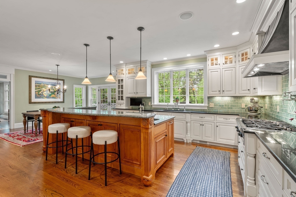 200 Edgewater Drive Needham, MA 02492 - Photo 9 of 41 a kitchen with stainless steel appliances granite countertop a stove top oven a sink dishwasher and white cabinets with wooden floor
