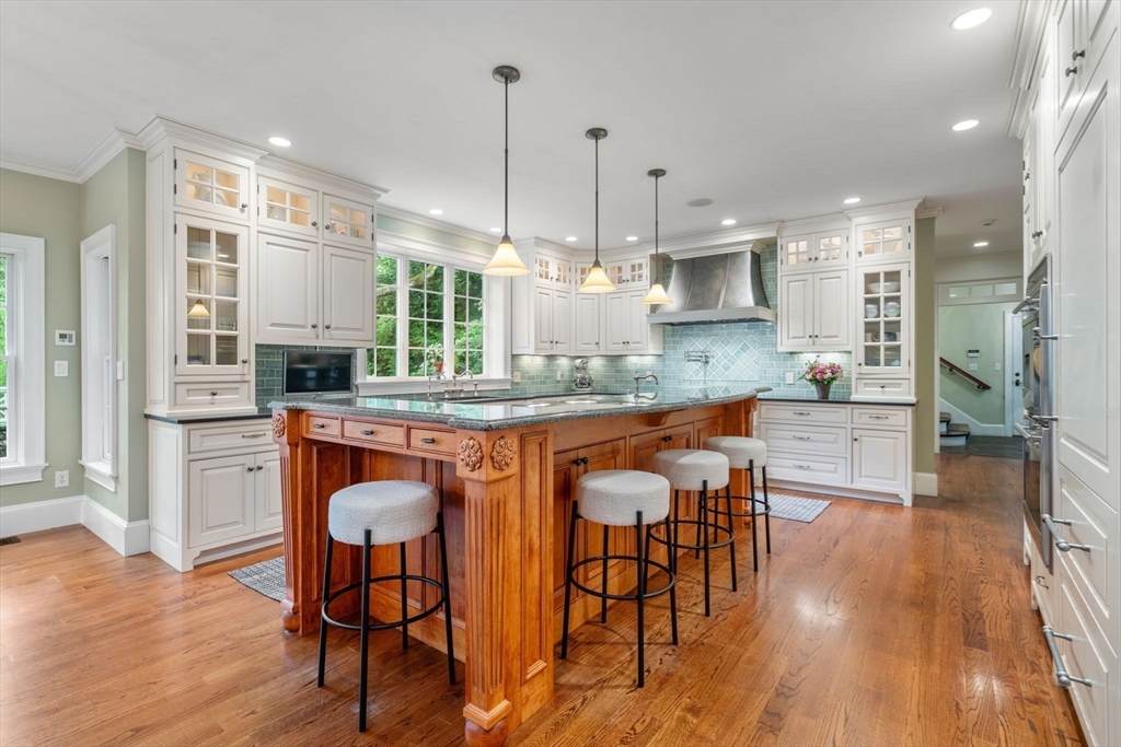 200 Edgewater Drive Needham, MA 02492 - Photo 10 of 41 a kitchen with stainless steel appliances granite countertop wooden floors stove and white cabinets