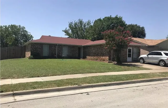 a view of a house with a yard and large tree