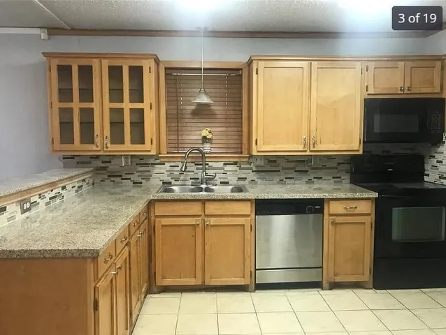 a kitchen with granite countertop a sink and a stove