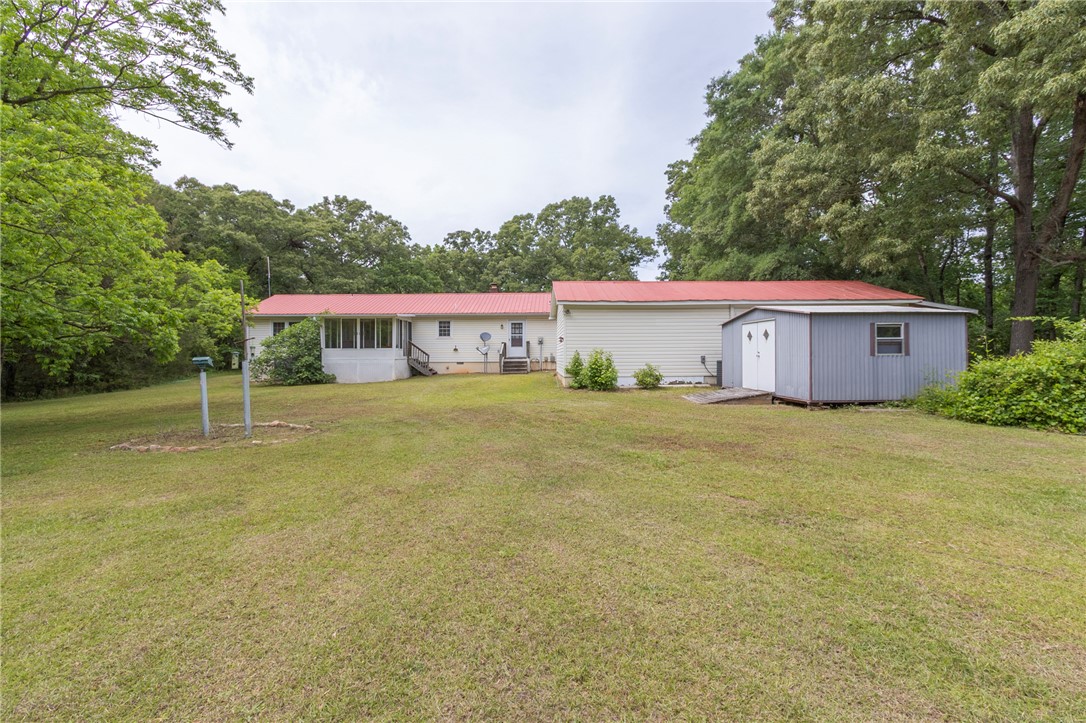 1116 Leatherdale Road Iva, SC 29655 - Photo 14 of 46 This expansive yard features a charming home with a bright red roof and convenient storage shed.
